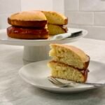 Slice of Victoria sponge cake with jam on a plate