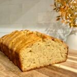 Sliced golden syrup banana bread loaf on a wooden board