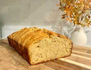 Sliced golden syrup banana bread loaf on a wooden board